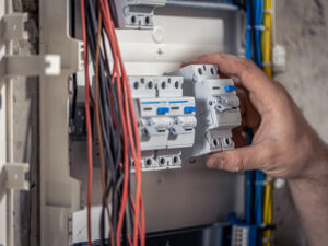 male-electrician-works-switchboard-with-electrical-connecting-cable.jpg